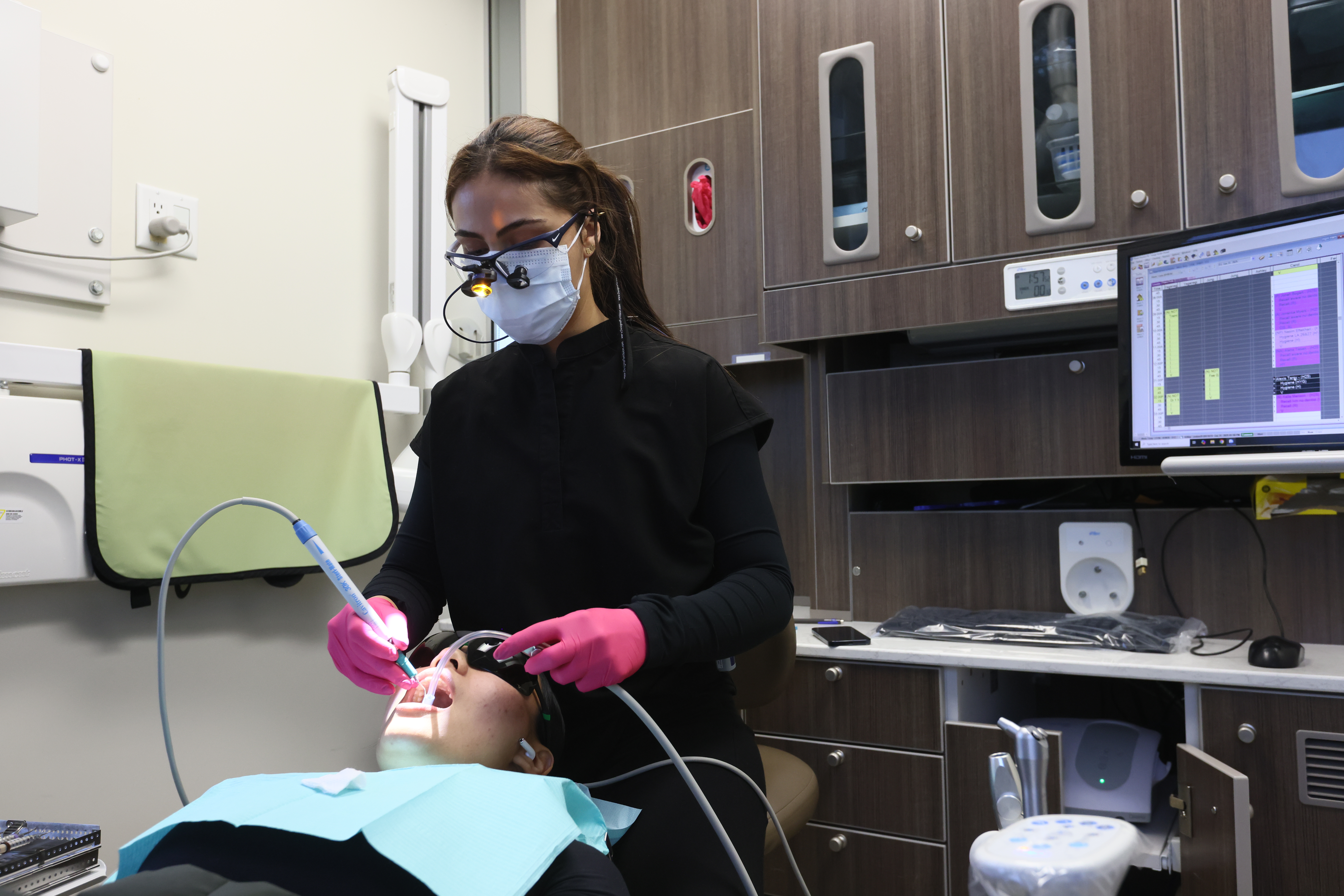 A dental hygienist treating a patient chairside